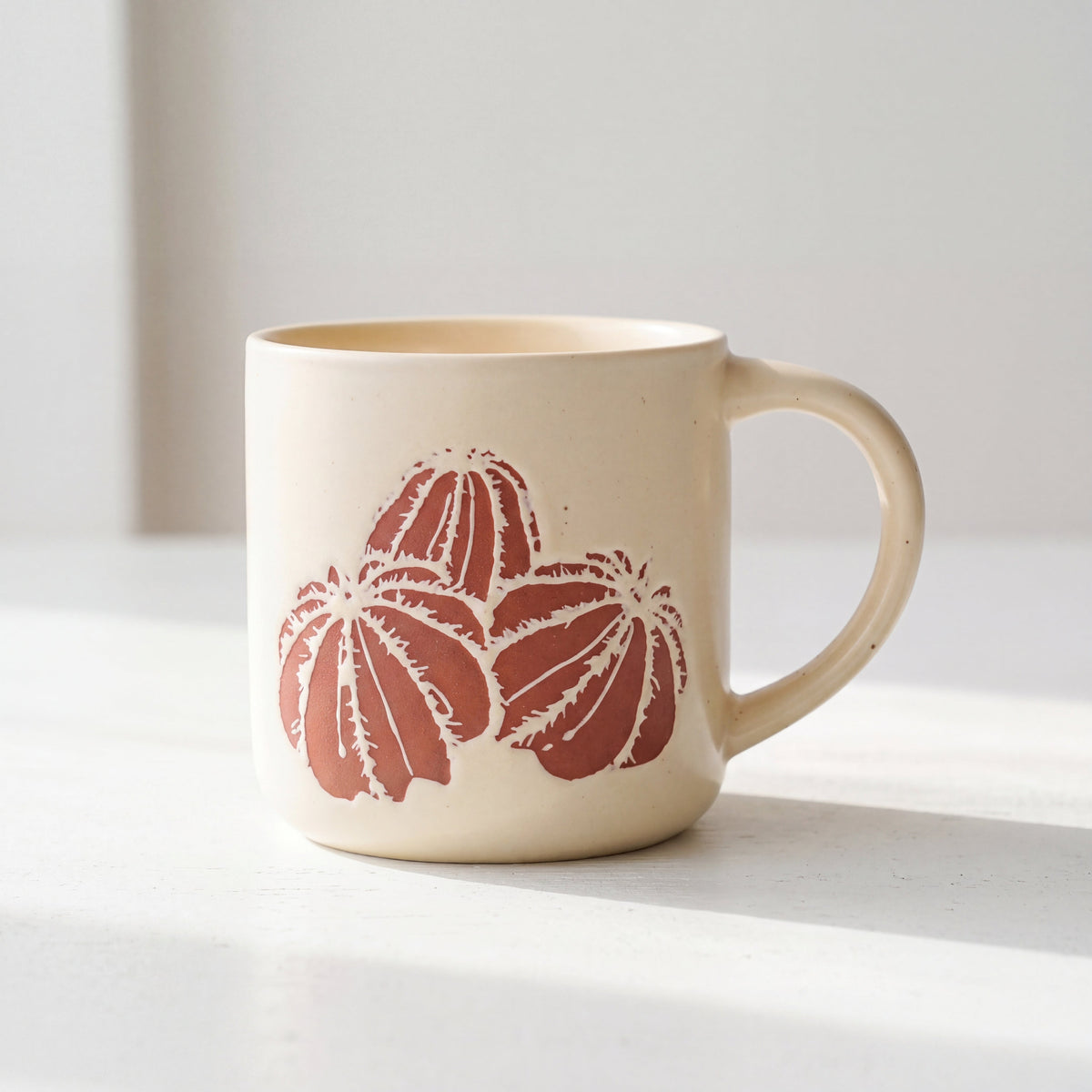 ROOT24STUDIO The Cactus Mug featuring raised terracotta barrel cactus relief on speckled ceramic