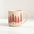 ROOT24STUDIO The Evergreen Mug featuring panoramic terracotta pine tree forest motif on speckled stoneware