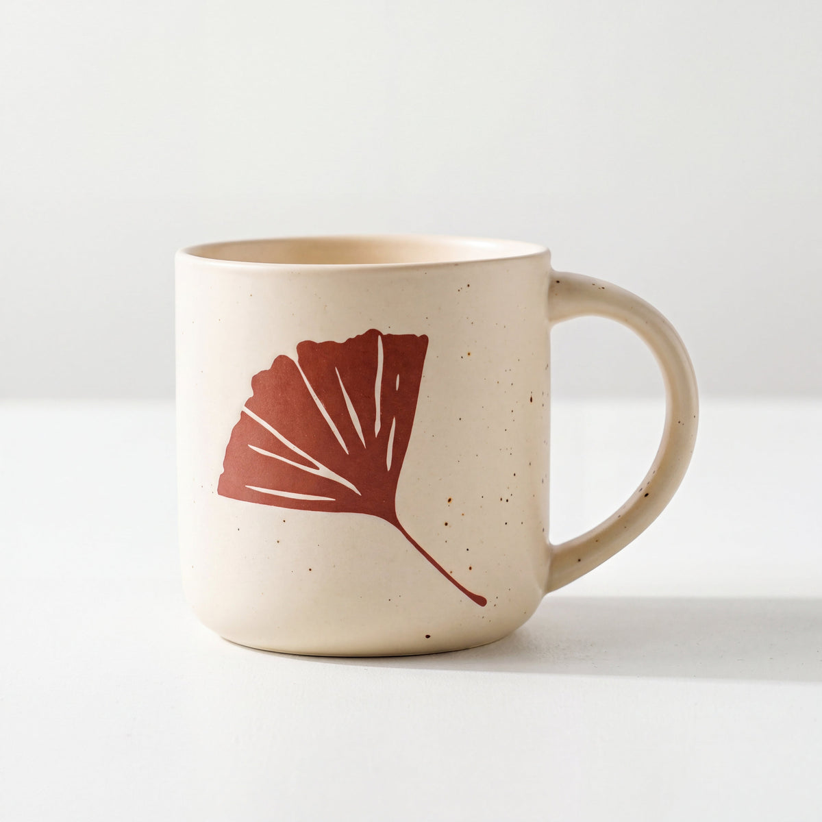 ROOT24STUDIO The Ginkgo Mug featuring raised terracotta fan leaf relief on speckled vanilla ceramic