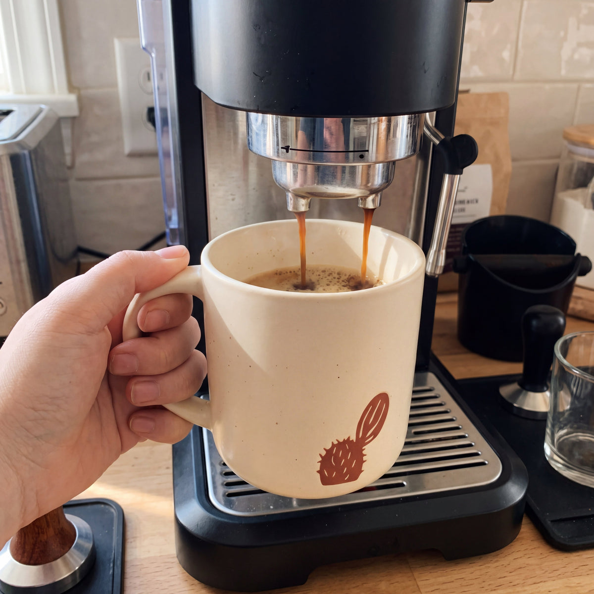 Brewing rich morning espresso directly into The Cactus ceramic mug on a modern home coffee station