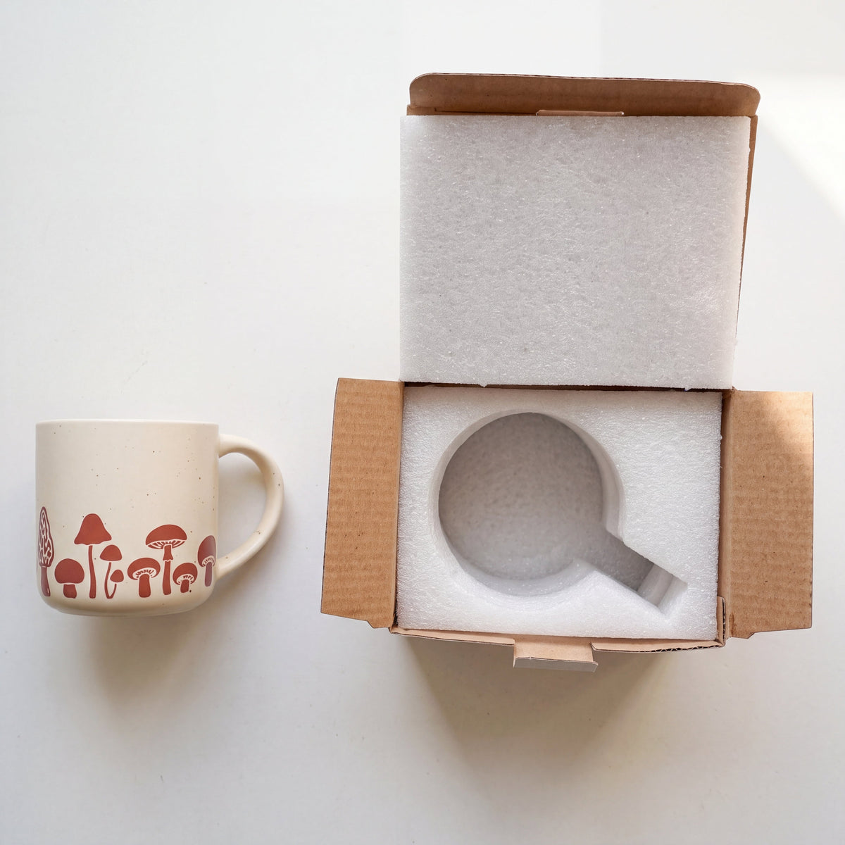 The Mushroom stoneware mug securely packed in custom protective foam inside a DTC gift box