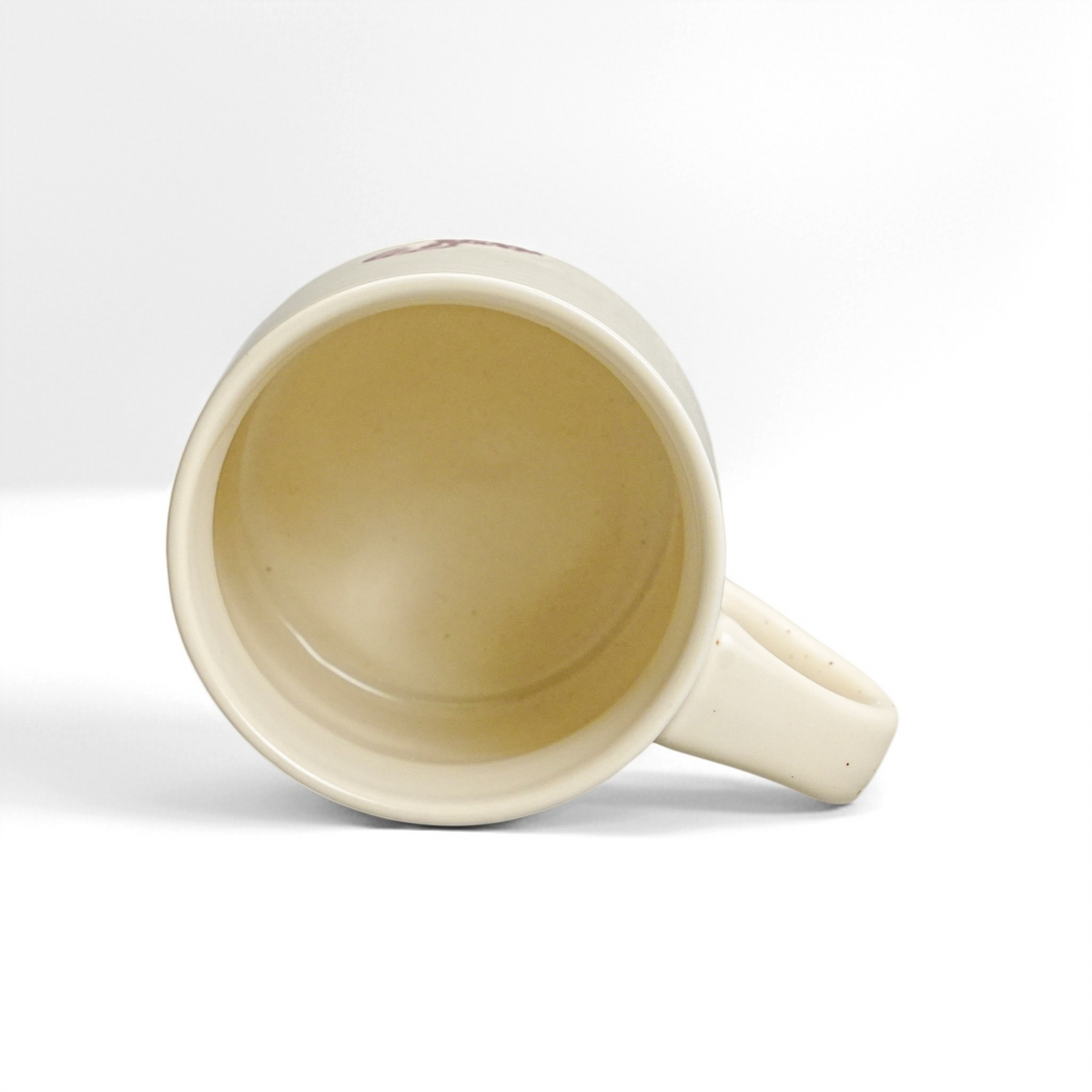 Top interior view of 12oz ceramic coffee mug showing glossy food-safe vanilla glaze and handle