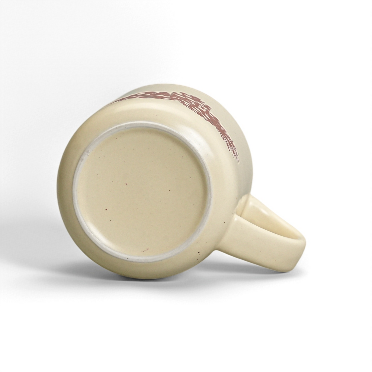Unglazed raw stoneware foot ring and smooth ceramic base of The Pinecone mug