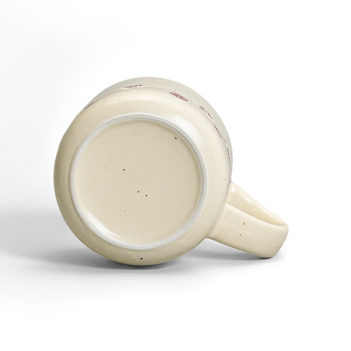 Unglazed raw stoneware foot ring and smooth ceramic base of The Wild Strawberry Mug
