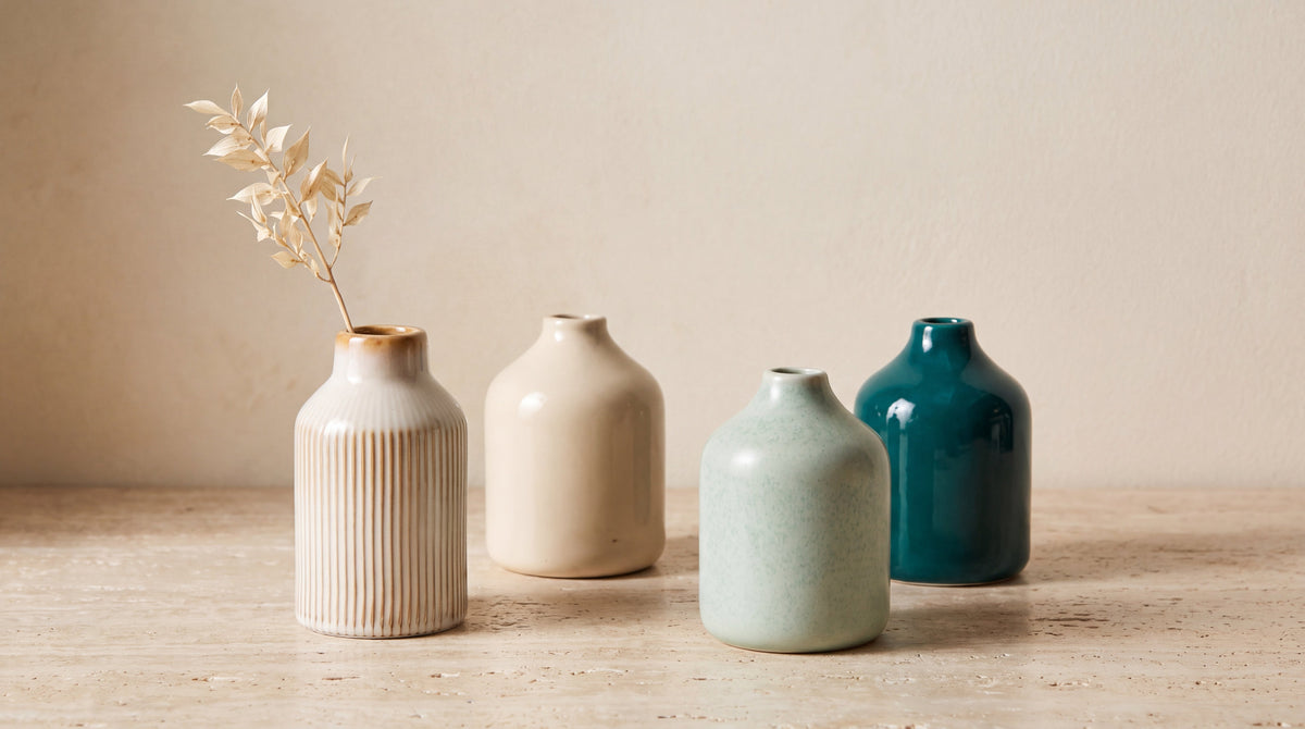 Handcrafted ceramic bud vases in celadon mint and cream, styled on travertine stone with a dried botanical stem for ROOT24STUDIO.
